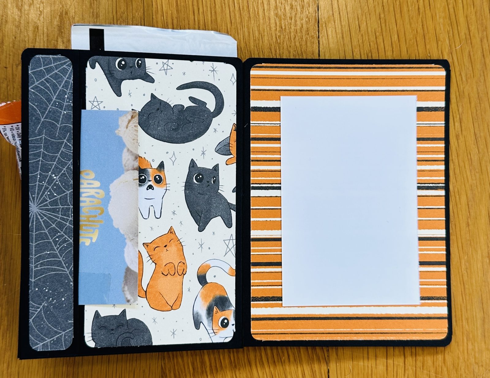 Inside of the Halloween treat holder card showing a gift card tucked in the inside pocket next to a striped panel for a sentiment