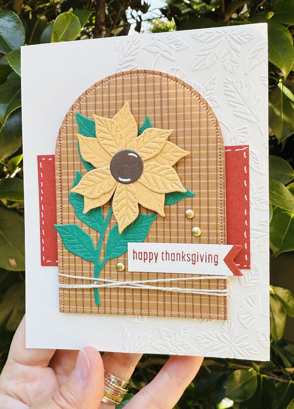 Close-up of a handmade Thanksgiving card with a Golden Glow sunflower and Shaded Spruce leaves