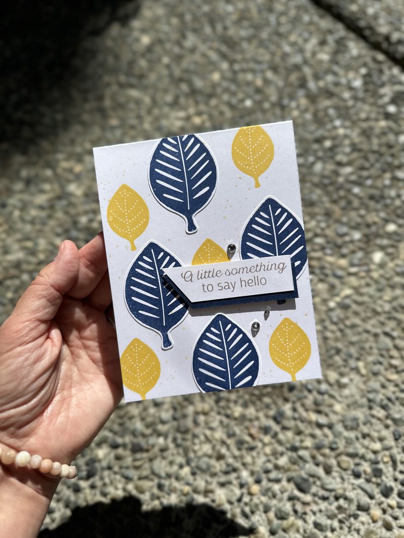 Handmade card with navy leaves and yellow Daffodil Delight leaf shapes, sentiment reads a little something to say hello